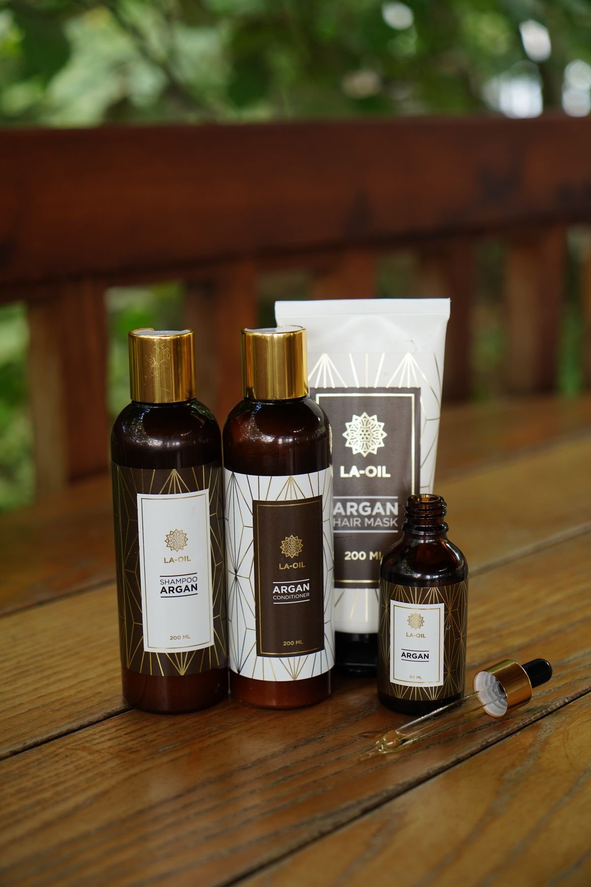 Hair growth and bond-building serums and oils arranged on a wooden surface