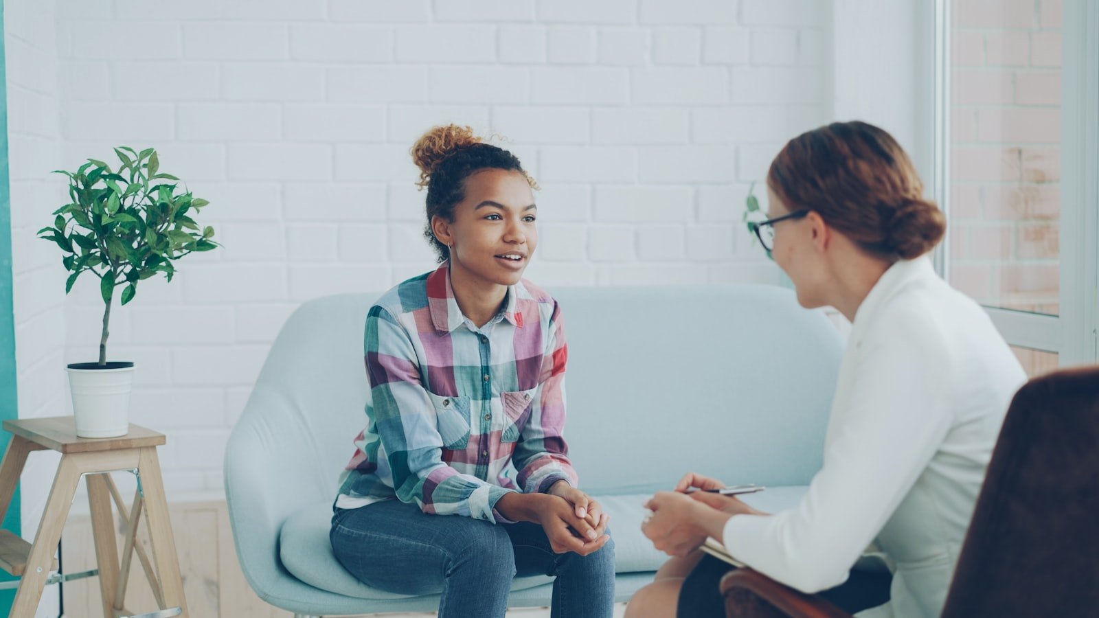 Counselor and client having a supportive conversation in a bright office