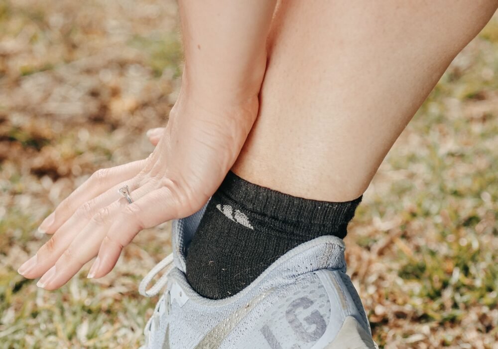 Person adjusting an athletic sneaker with a roomy toe box