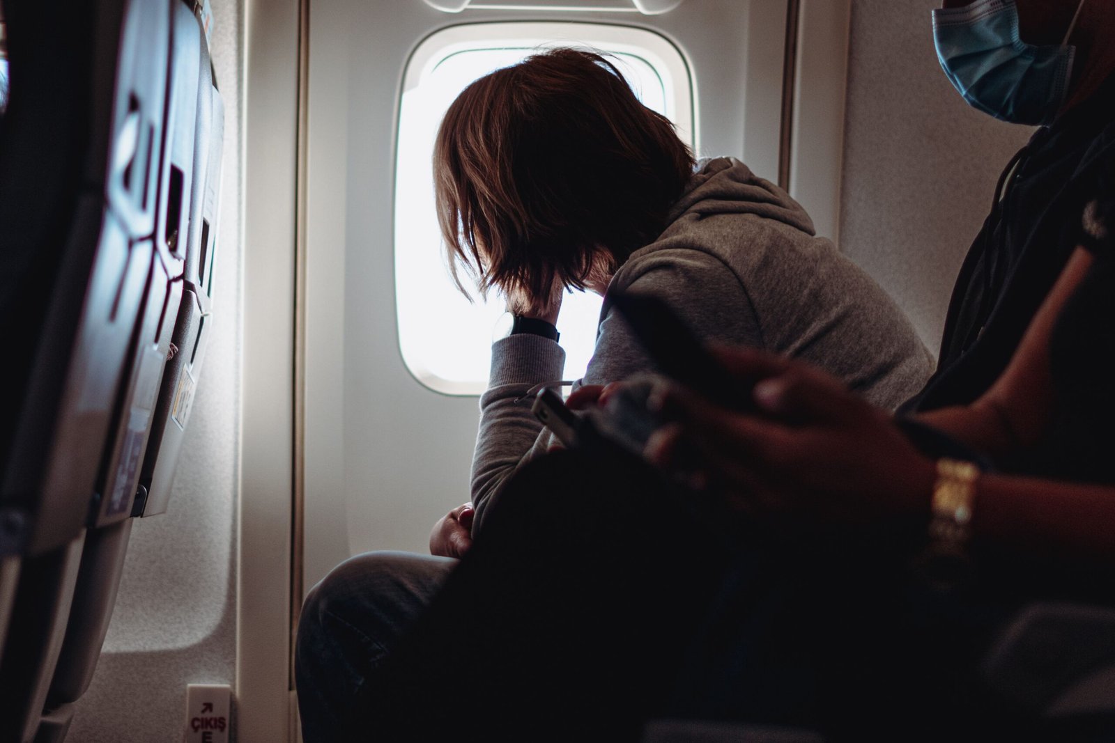 Airline passenger looking out of an airplane window during a flight