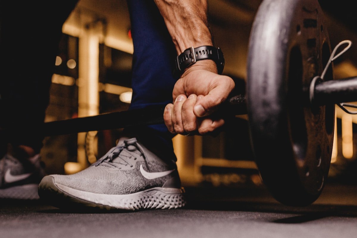 Person about to lift a loaded barbell off a bench press rack