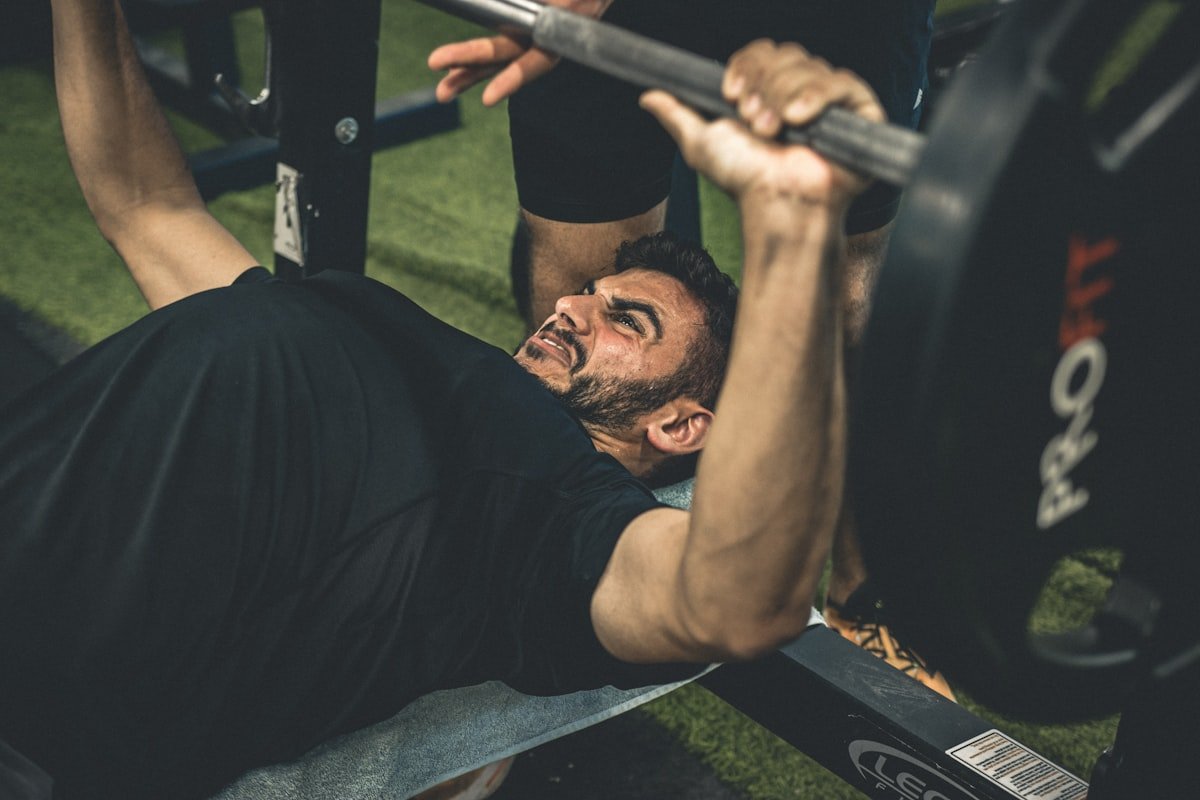 Man performing a barbell bench press for upper body strength