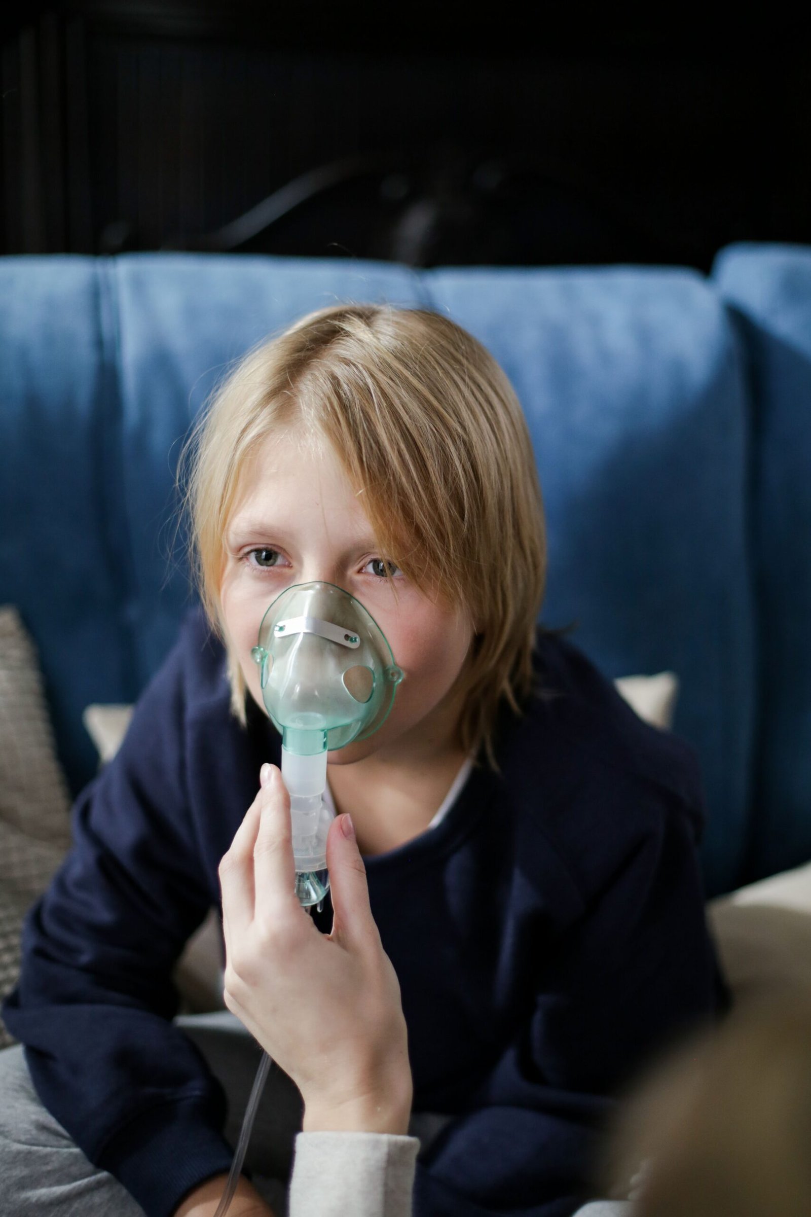 child holding nebulizer equipment at home