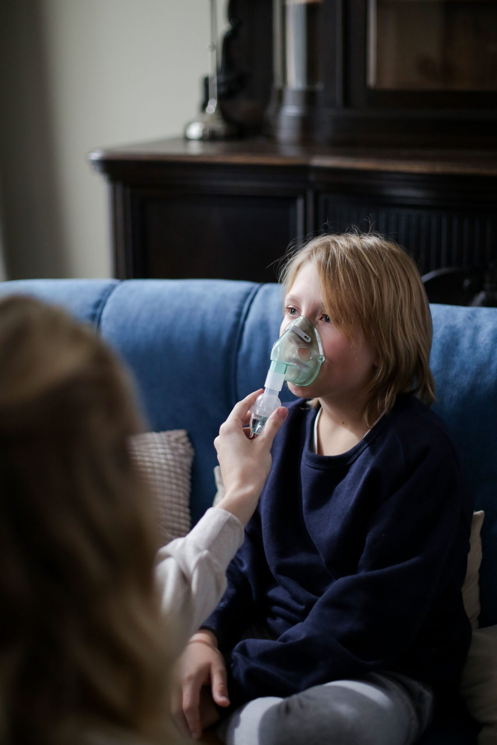 boy receiving nebulizer inhalation therapy at home
