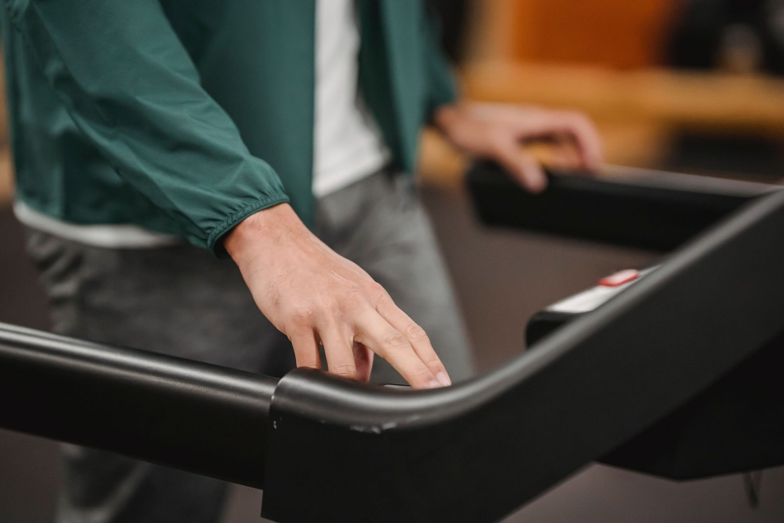 Console controls after a reset close-up of a hand pressing a button on a treadmill console