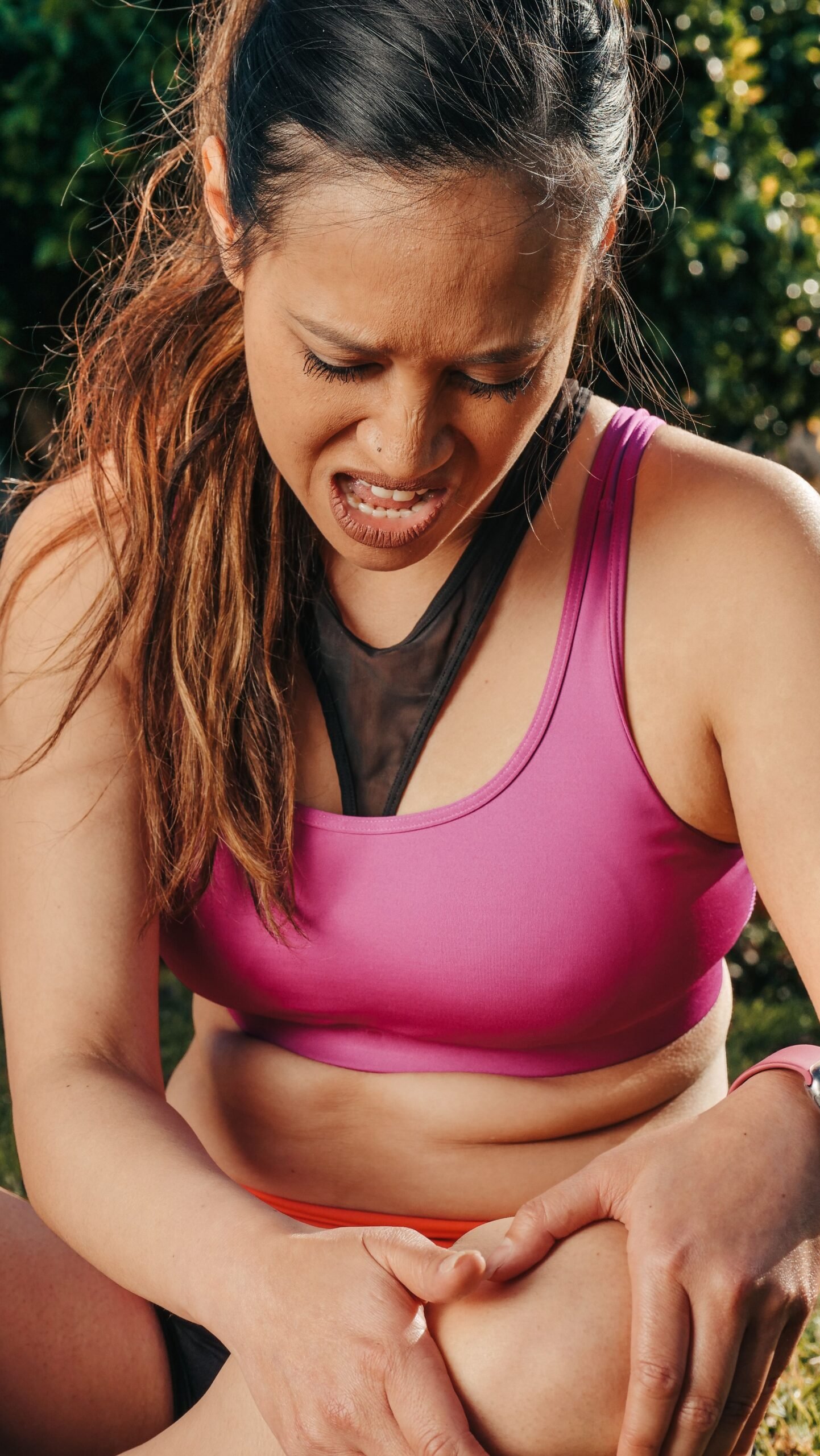 woman holding her knee in pain before wearing a brace