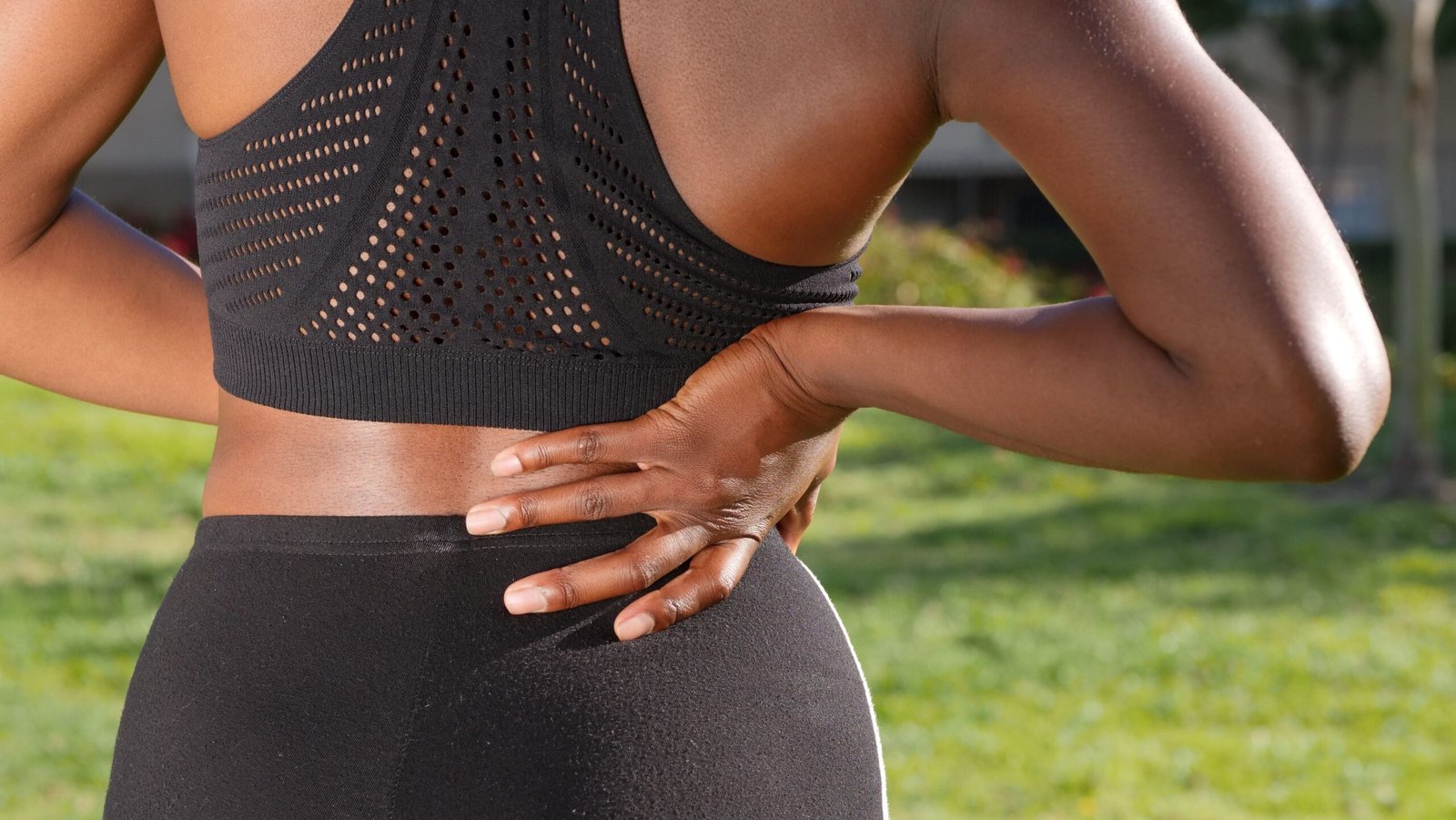 person holding lower back in pain