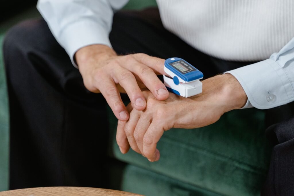 person checking blood oxygen level at home with a fingertip pulse oximeter
