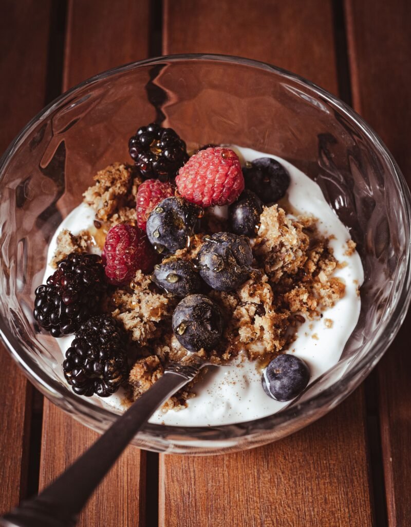 Bowl of yogurt with berries and granola, a simple way to enjoy probiotic rich foods at breakfast