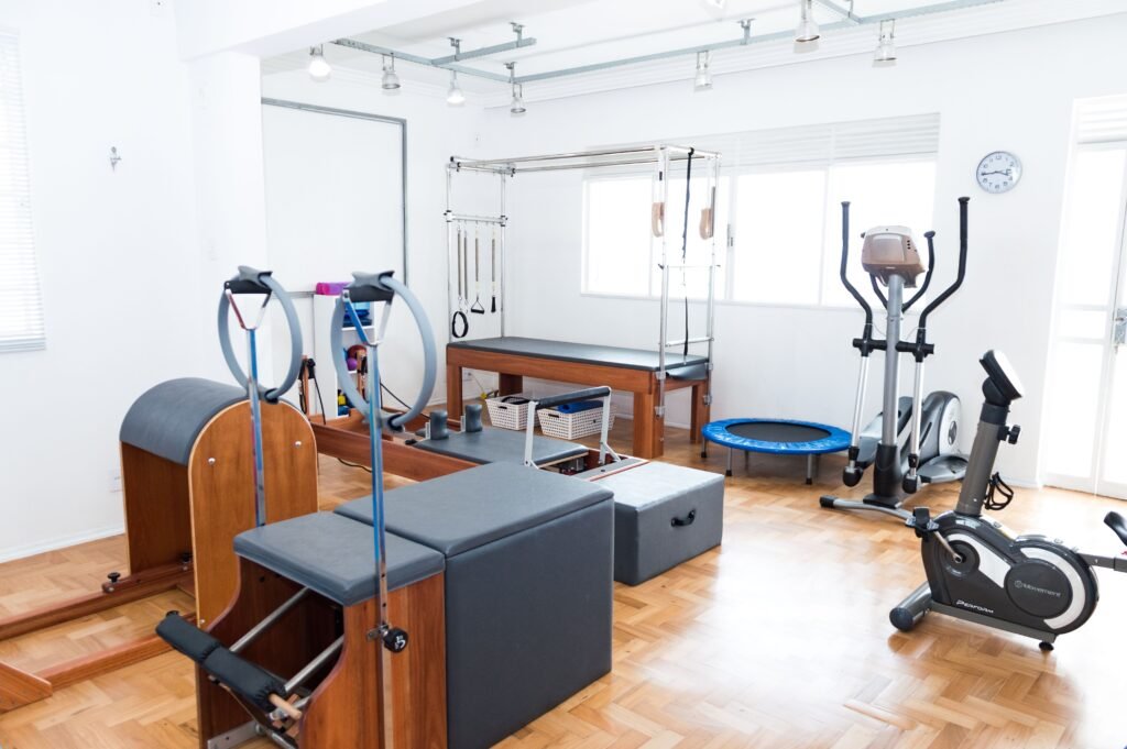 Bright home gym space with Pilates equipment and wood flooring