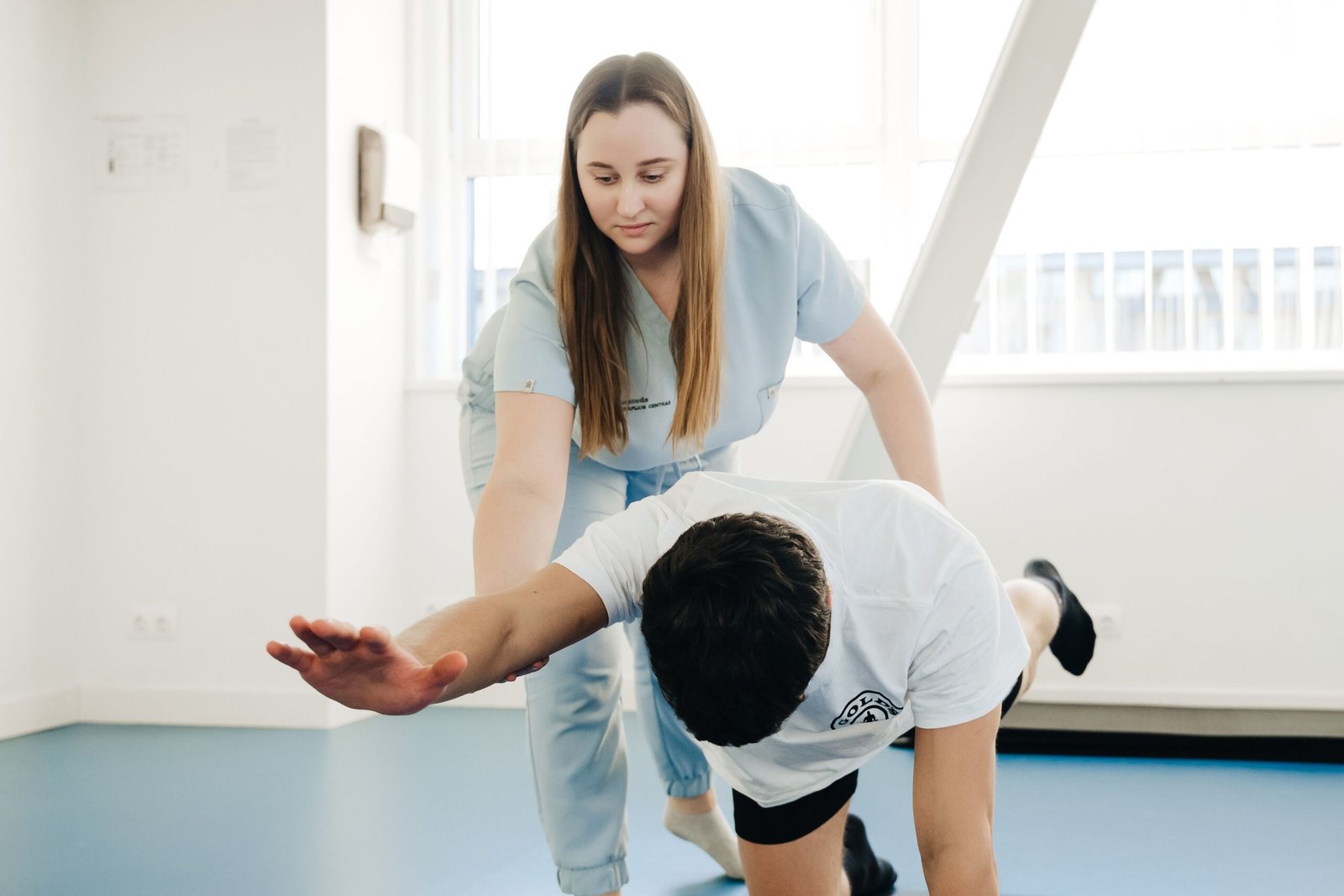 Physiotherapist assisting a patient with a guided stretching exercise