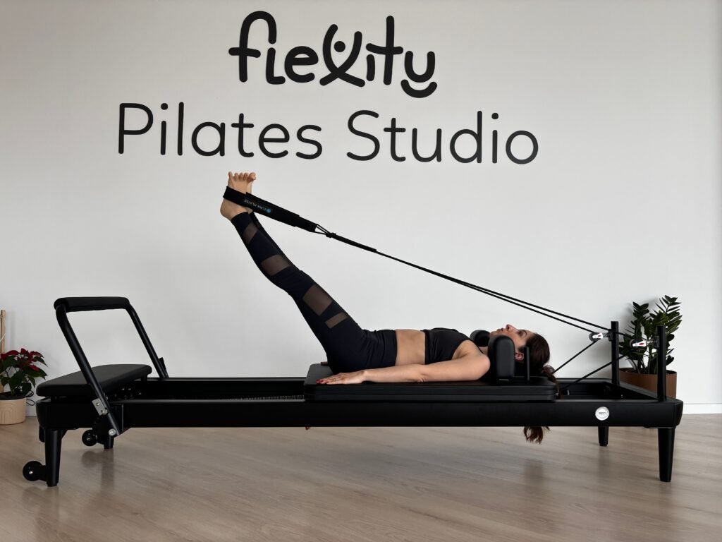 Woman exercising on a Pilates reformer in a studio