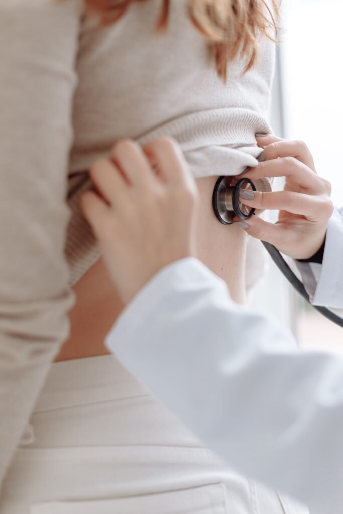 doctor using a stethoscope on a patient's back during an exam