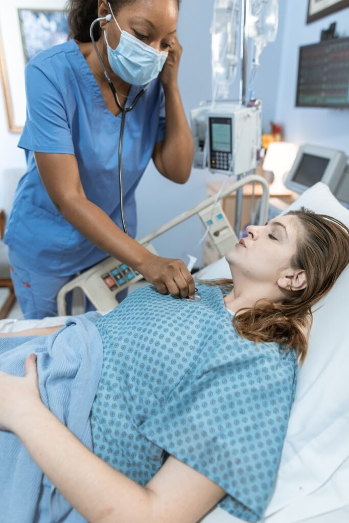 nurse using a stethoscope to check a patient