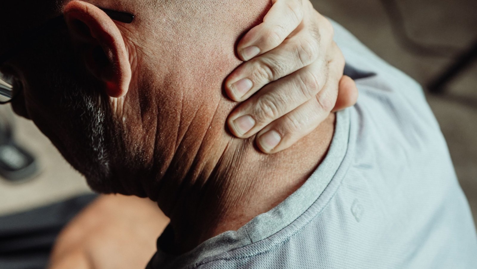 Man holding his neck in discomfort from neck pain