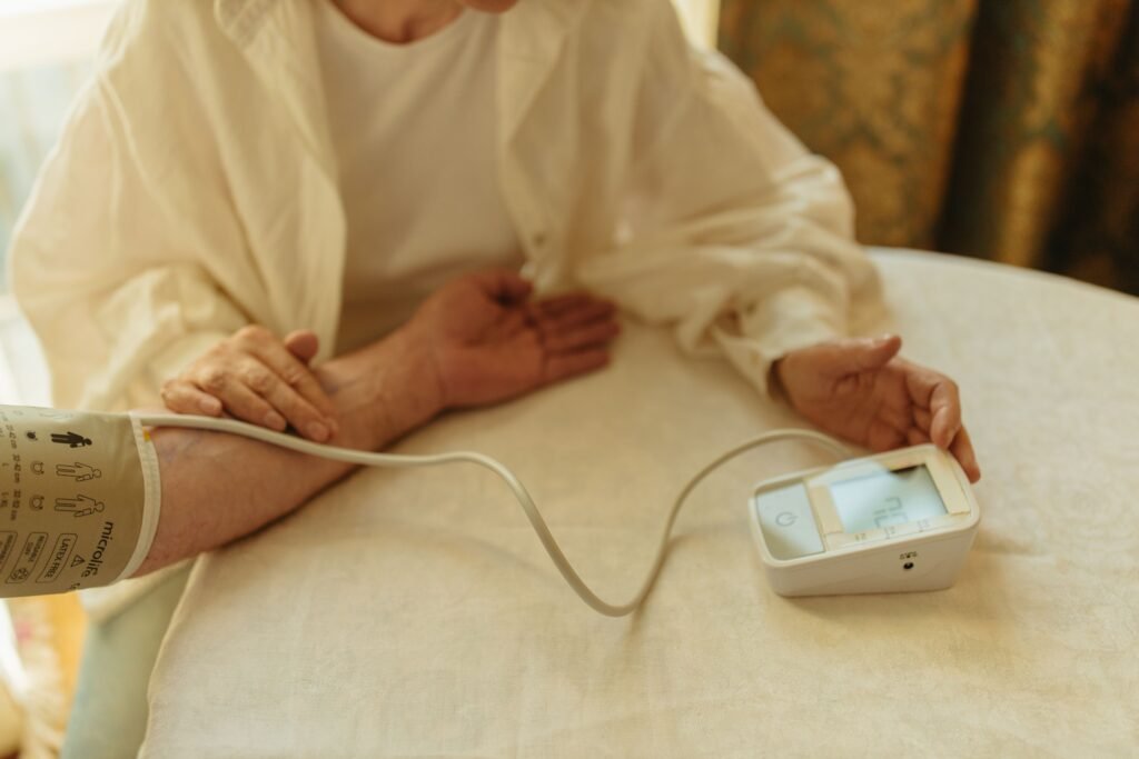person checking blood pressure with a digital home monitor